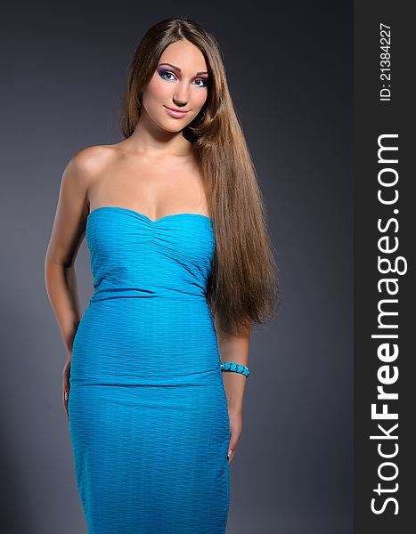 Beutiful professionally makeup girl with long brown hair wearing blue dress. Beutiful professionally makeup girl with long brown hair wearing blue dress