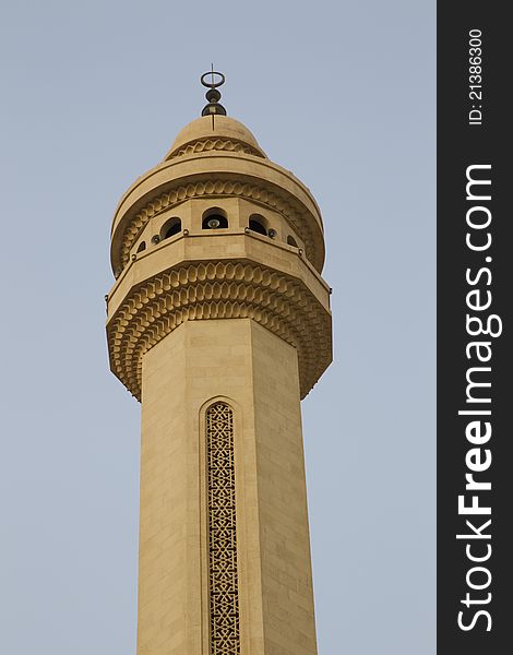Isolated view of a single minaret against a blue sky