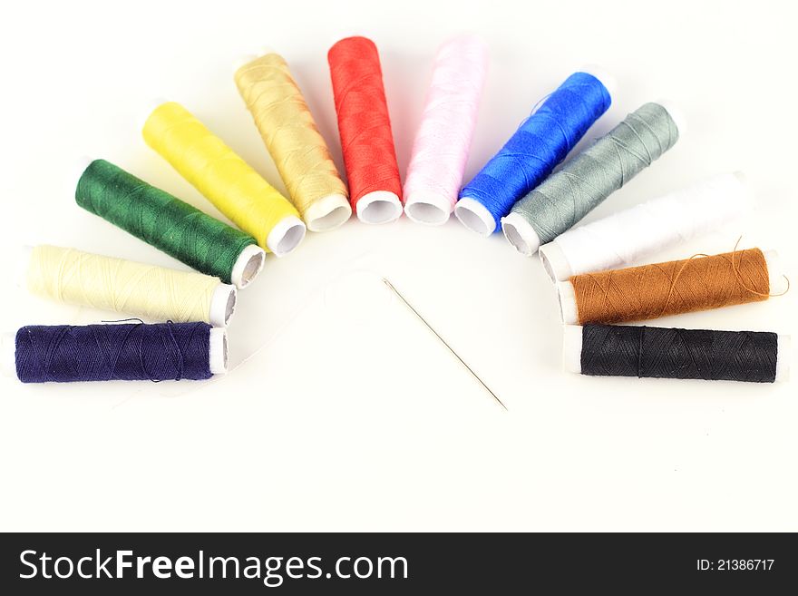 The color threads and needle  by semicircle pattern with isolated white background. The color threads and needle  by semicircle pattern with isolated white background