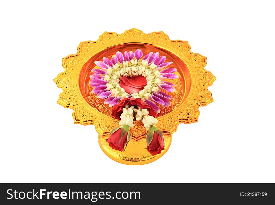 The garland decoration by orchid blooms and red roses on tray with pedestal.  Isolated over white background. The garland decoration by orchid blooms and red roses on tray with pedestal.  Isolated over white background.