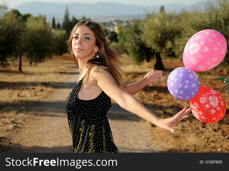Girl with balloons in the field in Granada