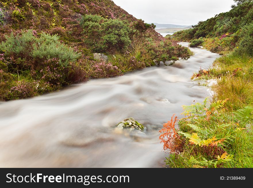 Mountain stream in heavy spate with smooth water flowing down