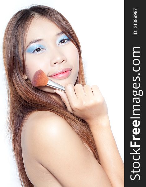 Beautiful young asian woman with make up brush