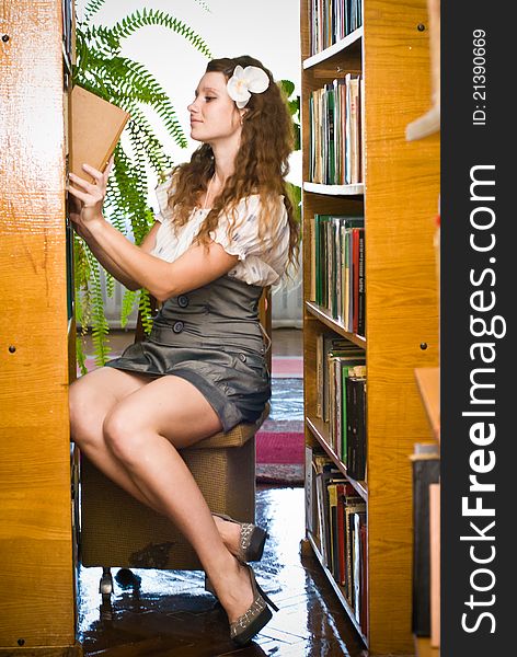 Young woman in library with a book in the hand