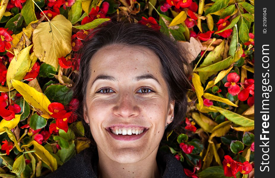 Russian young woman among leaves and flowers