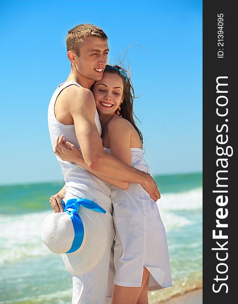 Portrait of young men and women embracing as a happy romentic couple on a beach. Portrait of young men and women embracing as a happy romentic couple on a beach.