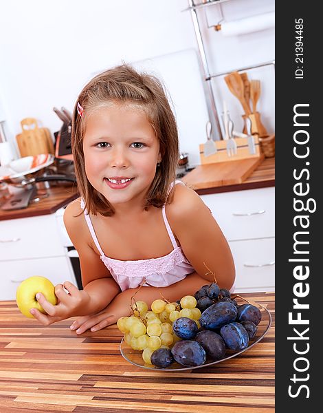 Smiling young girl in the kitchen with fresh fruits. Smiling young girl in the kitchen with fresh fruits