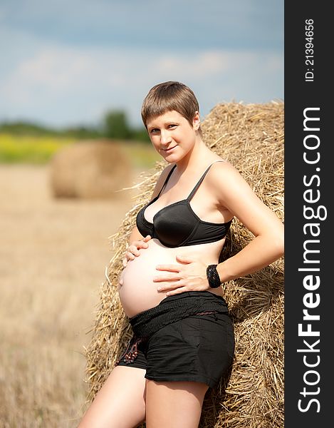Pregnant woman with big belly on the field. Pregnant woman with big belly on the field