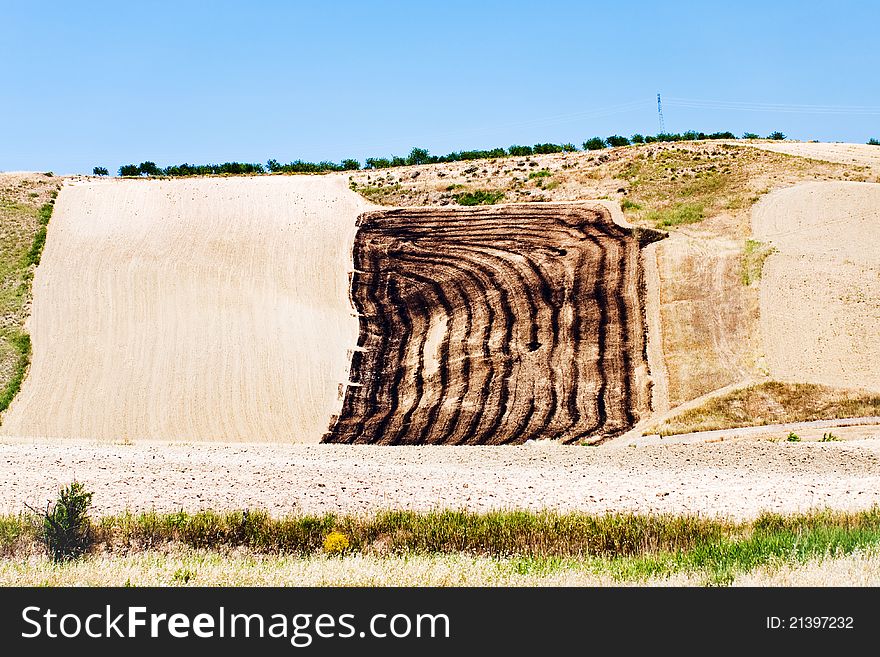 Harvested fields on hill slope in Sicily in summer day