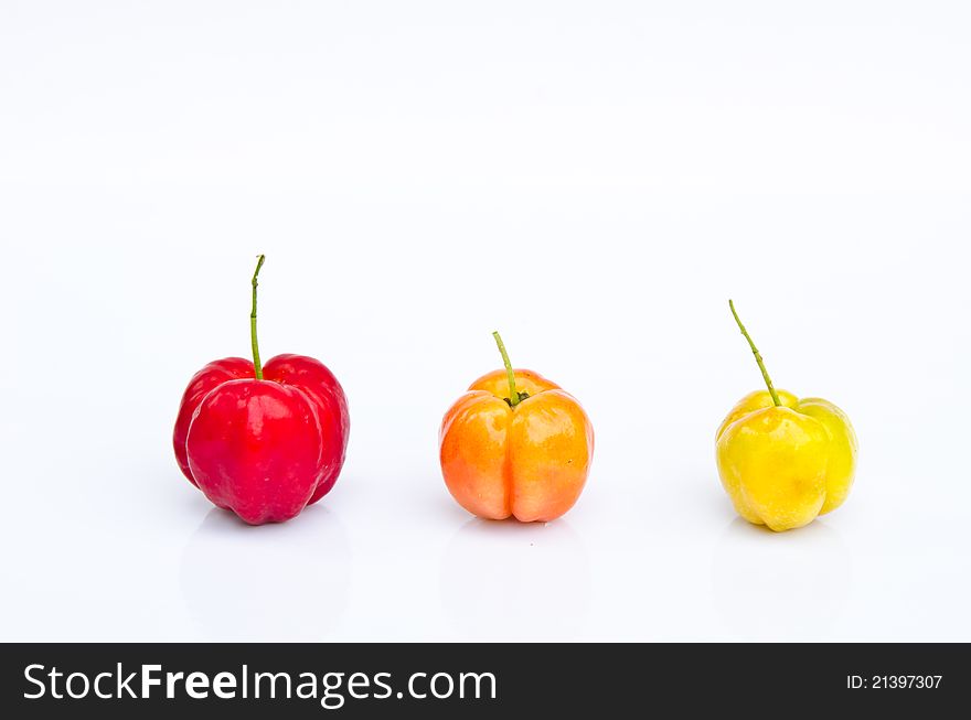 Row of three color cherry fruits on white background