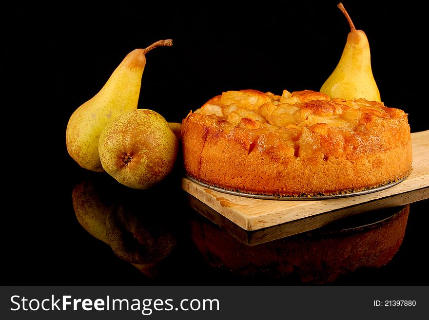 Pear Cake. Close up on black background. Fresh pears in background