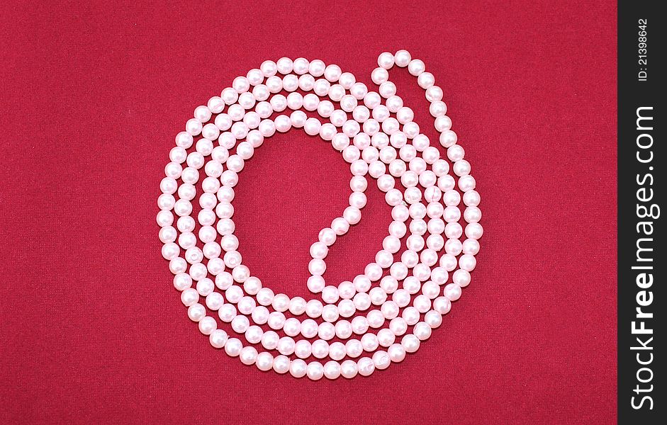 Light pink pear chains on display on red background. Light pink pear chains on display on red background