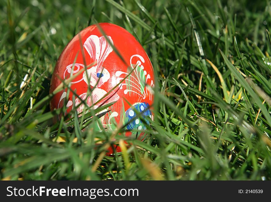 Red painted  easter egg with green background for europe