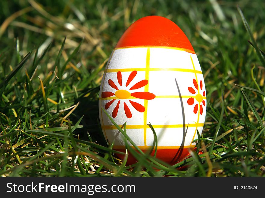 Red and white painted  easter egg with green background for europe