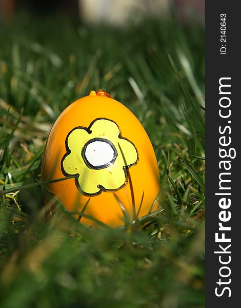 Yellow painted easter egg with green background