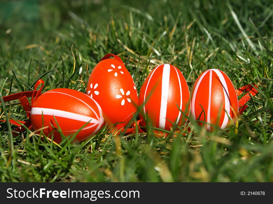 Four red painted easter egg with green background. Four red painted easter egg with green background