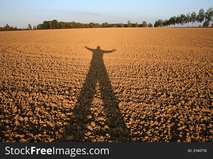 Shadow of person cast over field. Shadow of person cast over field