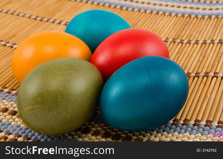 Five easter eggs on bamboo mat