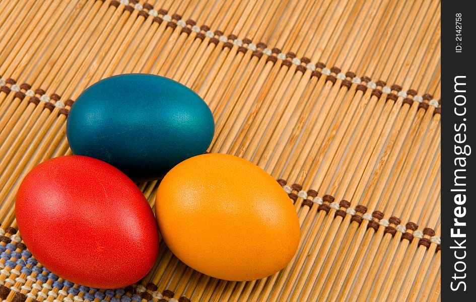 Three easter eggs on bamboo mat