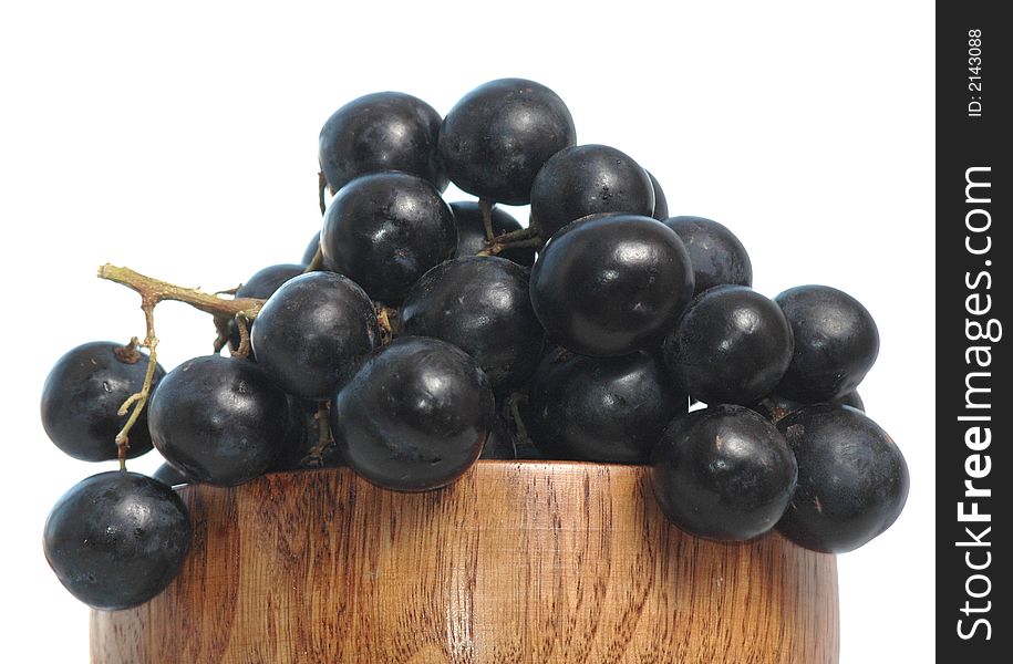Grape in wooden vase on white background