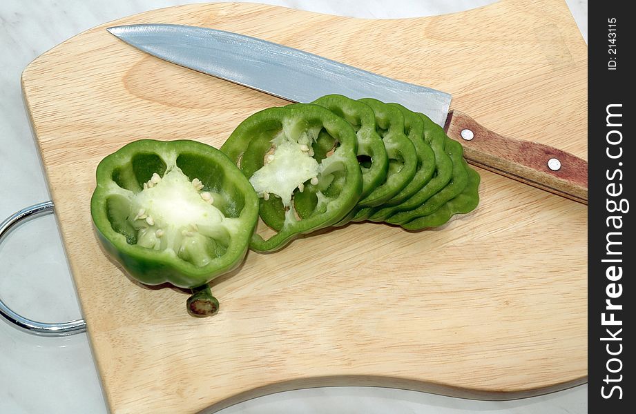 Green pepper cut on mugs on table