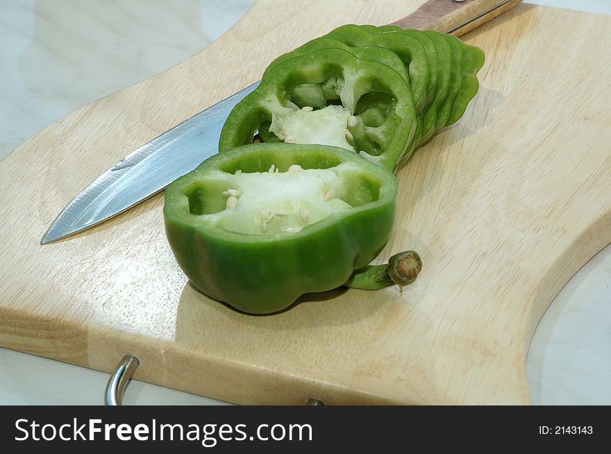 Green pepper cut on mugs on table