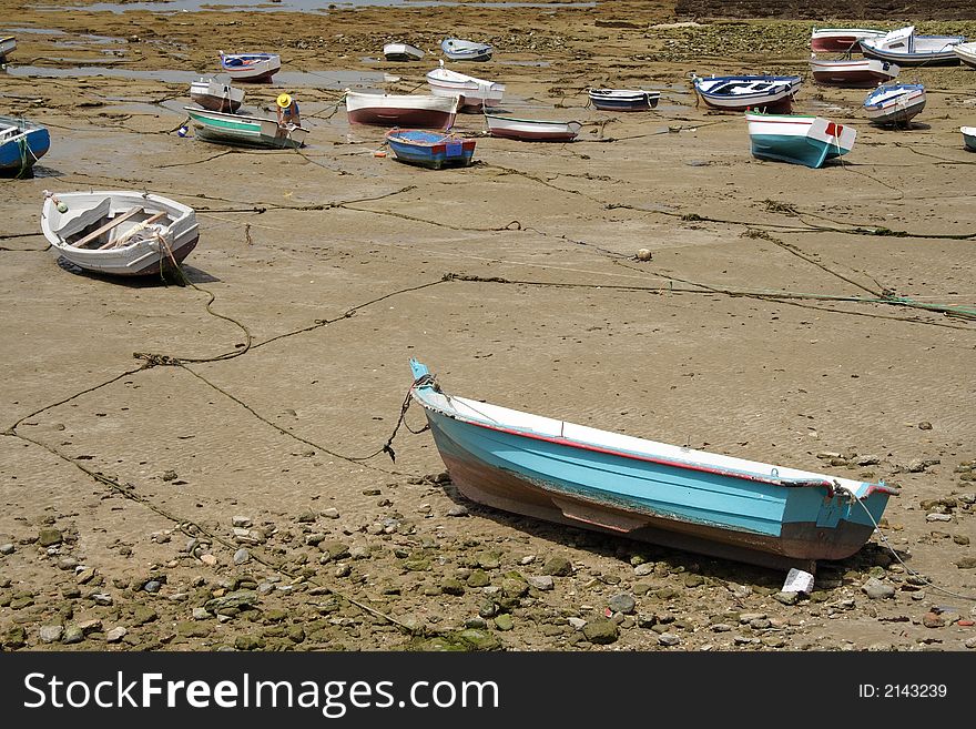 Small fishing boats while low tide on the ocean bed. Small fishing boats while low tide on the ocean bed