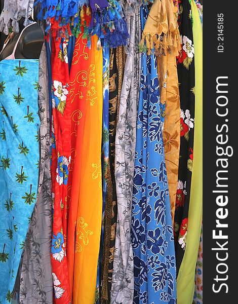 A display of colorful fabrics hanging at a market. A display of colorful fabrics hanging at a market