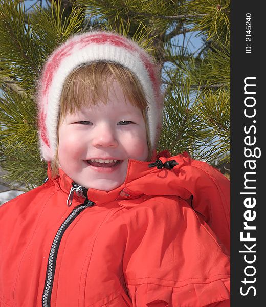 Pretty small girl in the red jacket smiles