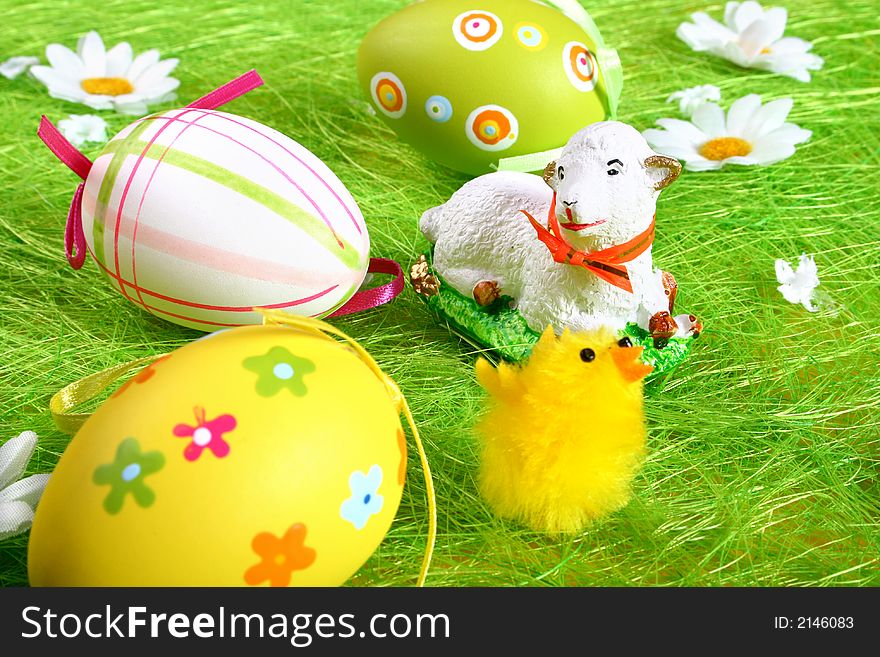 Closeup of several Easter eggs over green grass.