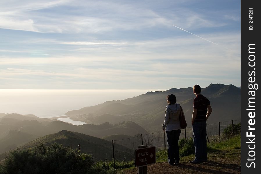 A couple watching ocean sunset. A couple watching ocean sunset