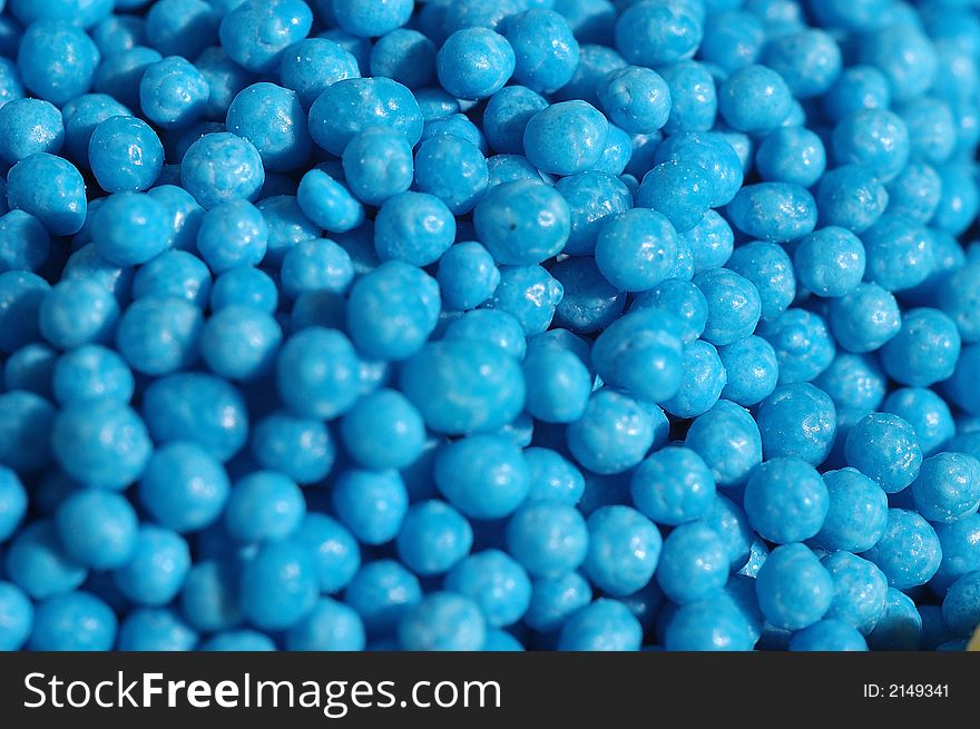 Small blue candies in a small glass on a saucer