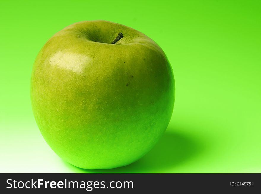 Appetizing apple of green color on a brightly green background