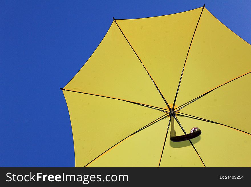 Yellow umbrella under blue sky.