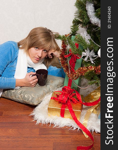 A young woman lies  near a new-year tree. A young woman lies  near a new-year tree