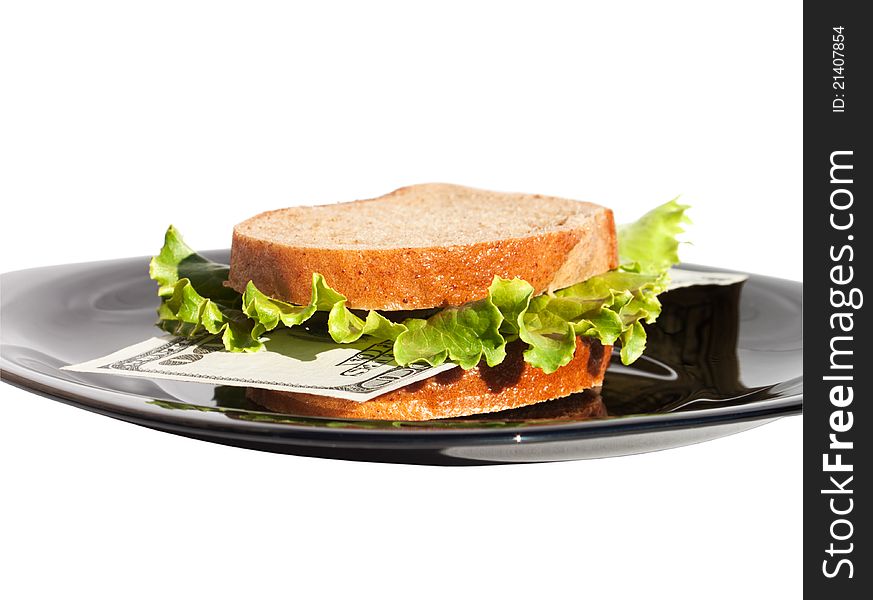 The sandwich with bank note and lettuce on the black plate at the white background which is a conception of rich, wealthy life