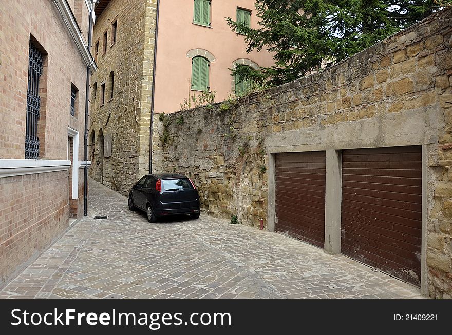 Garage on narrow street and black car