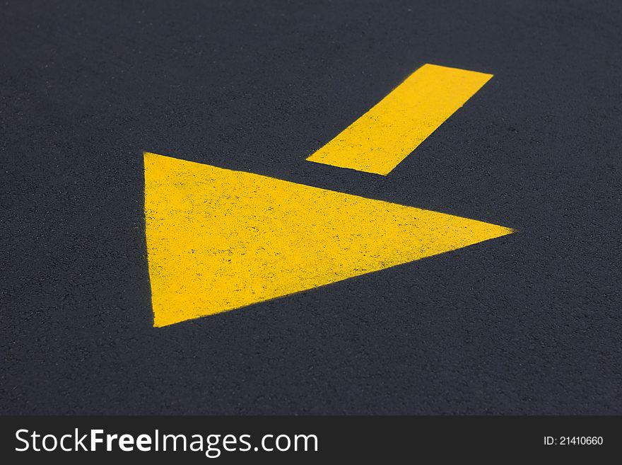 Yellow directional traffic arrow in the road. Yellow directional traffic arrow in the road