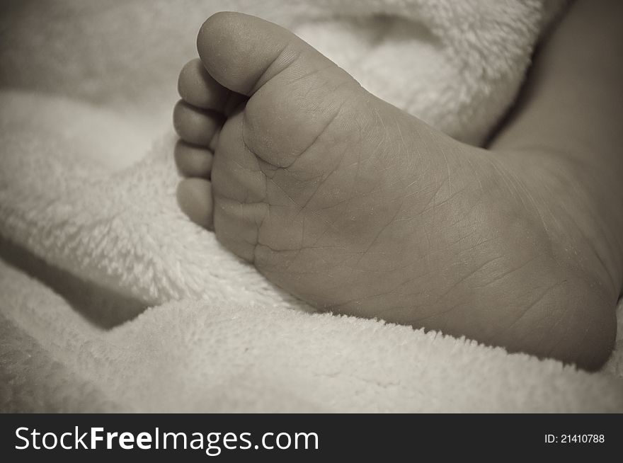 Aged baby foot on comforter