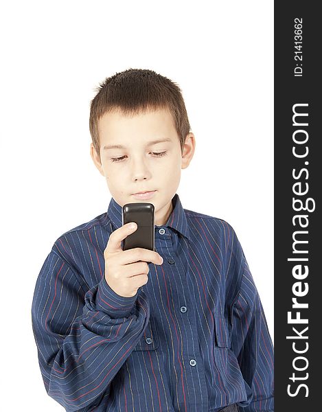 The young eleven-year teenager looks at a mobile phone which has control over. The young eleven-year teenager looks at a mobile phone which has control over