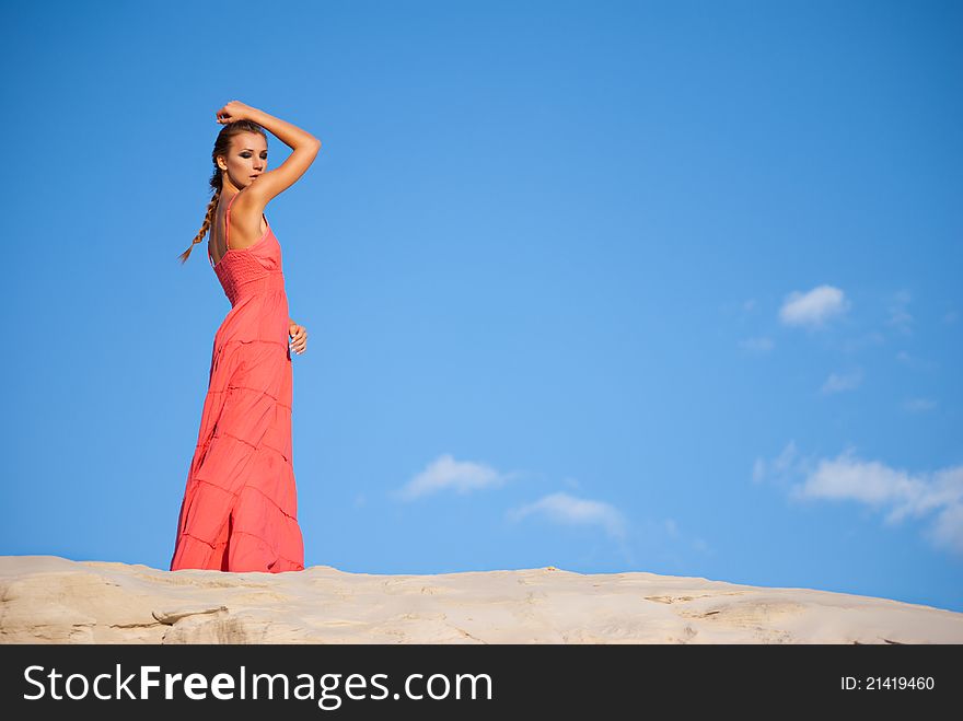 Beauty woman in red dress on the desert