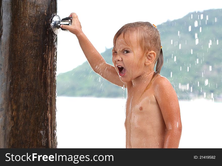 Little girl in the sea under a shower valve closes. Little girl in the sea under a shower valve closes