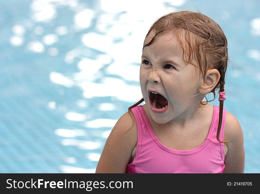 Little girl in the pool opened her mouth wide