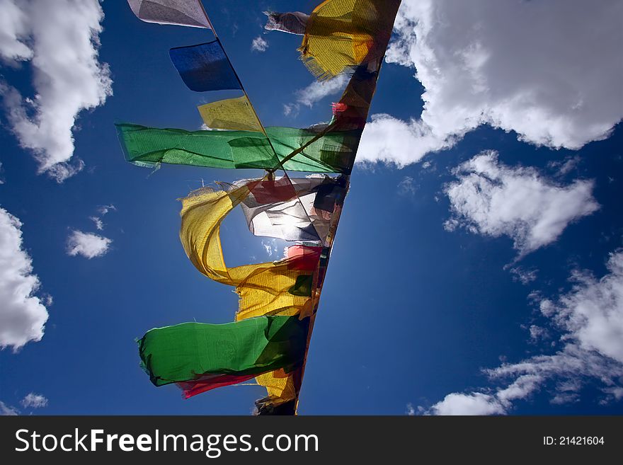 Praying flags floating in the wind on blue sky