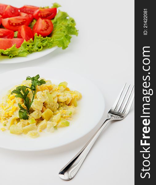 Fried zucchini with eggs and milk on white plate