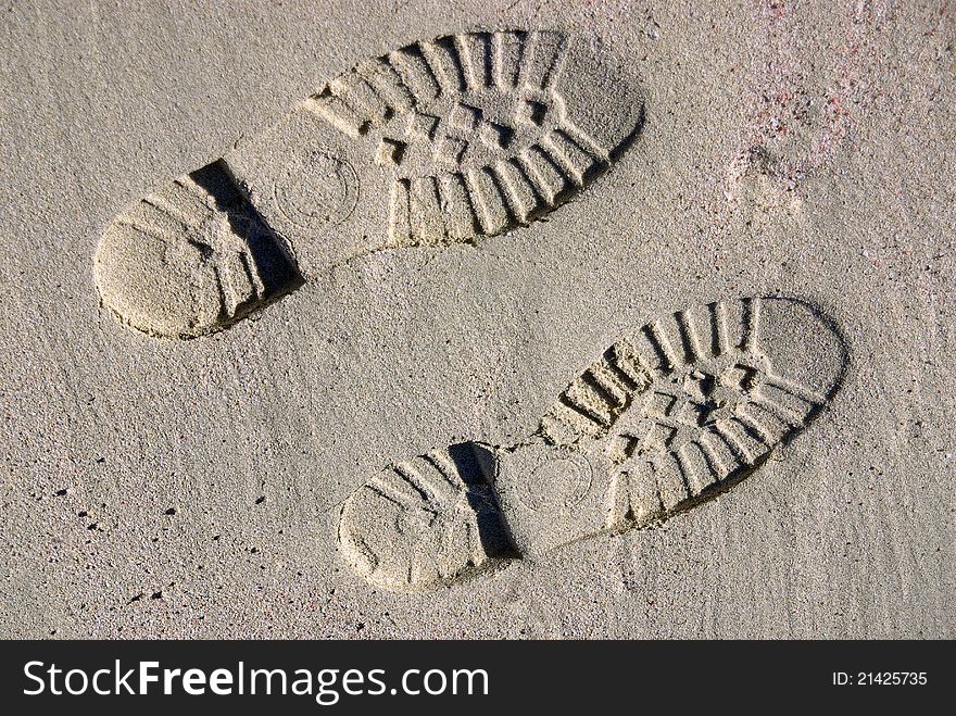 Boot footprints on the sand of a beach. Boot footprints on the sand of a beach