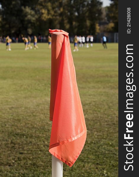 Orange corner flag close-up on the background of a football field