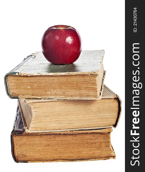 Stack of books with an apple on a white background