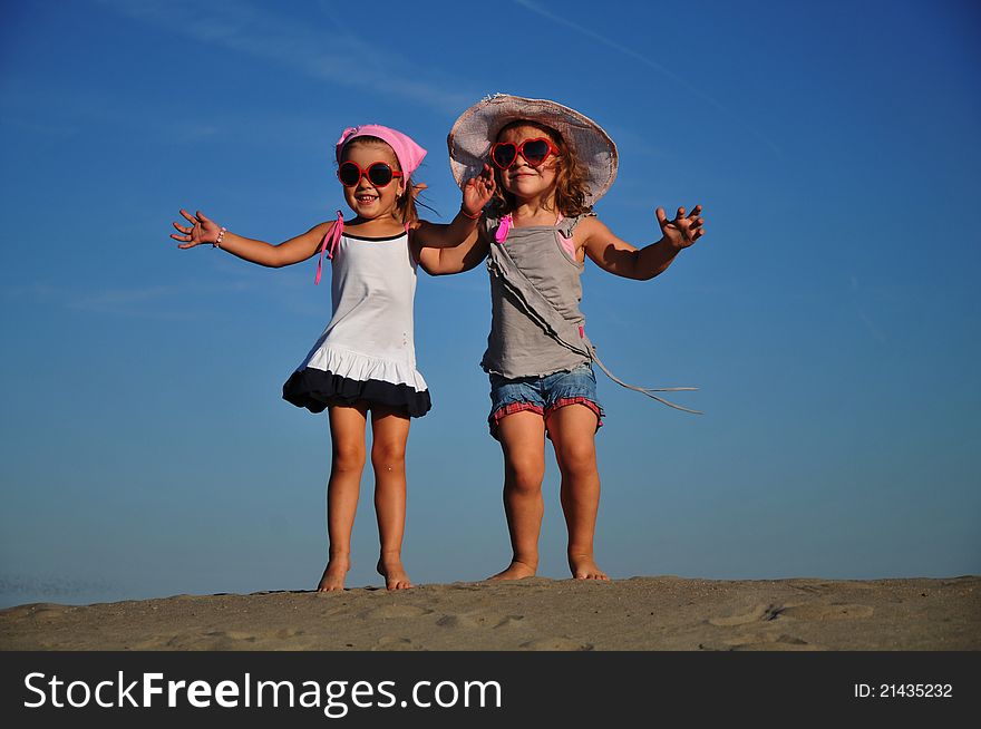 Girls Jumping On The Sandy Beach