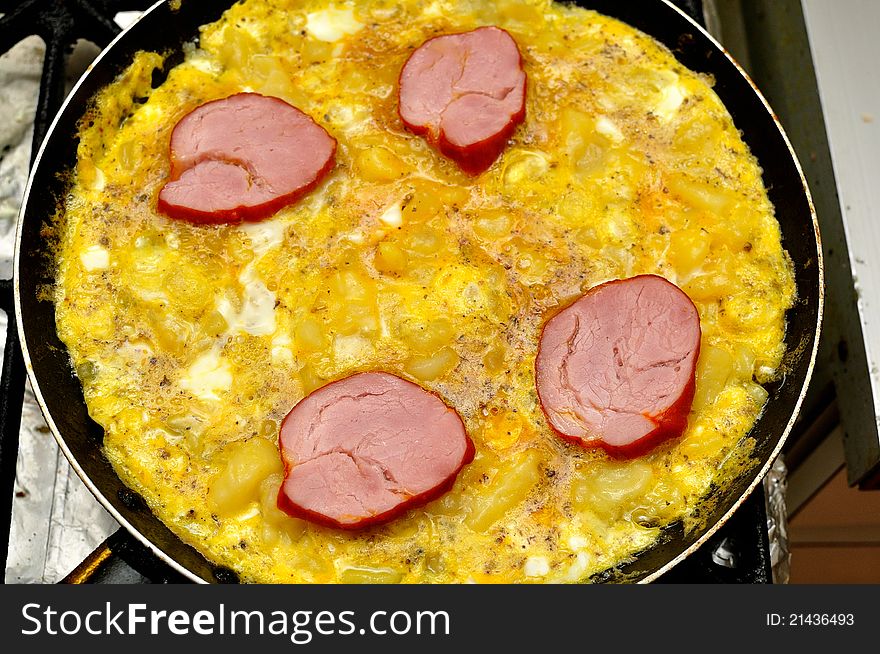 Breakfast omelet with ham in the pan
